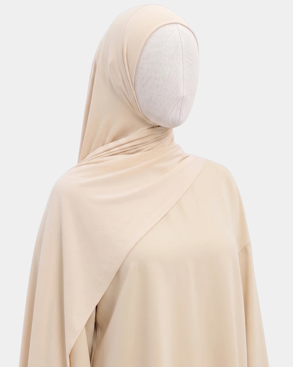 Hijab jersey modal beige porté de profil, drapé fluide sur l'épaule, tissu souple et respirant