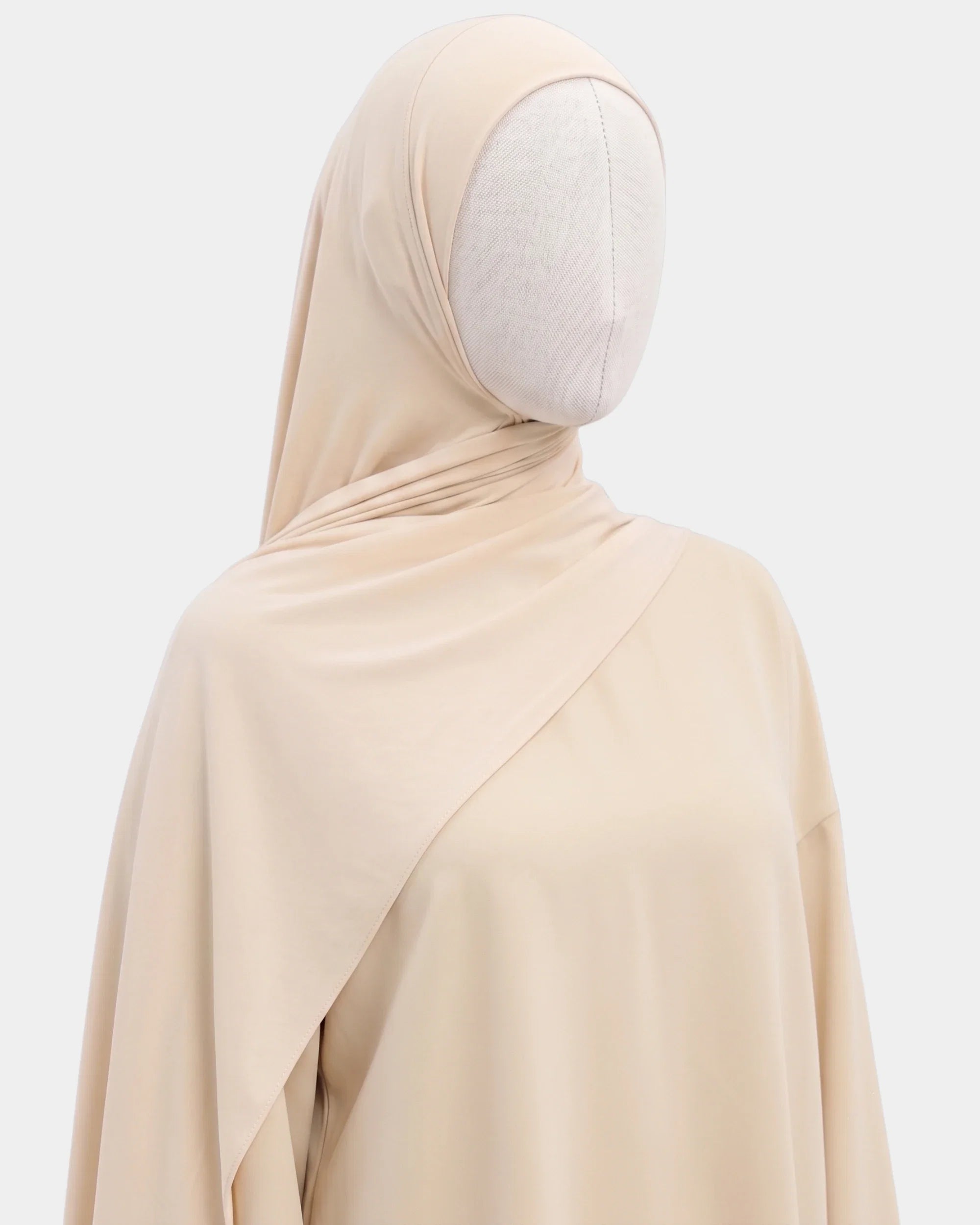 Hijab jersey modal beige porté de profil, drapé fluide sur l'épaule, tissu souple et respirant