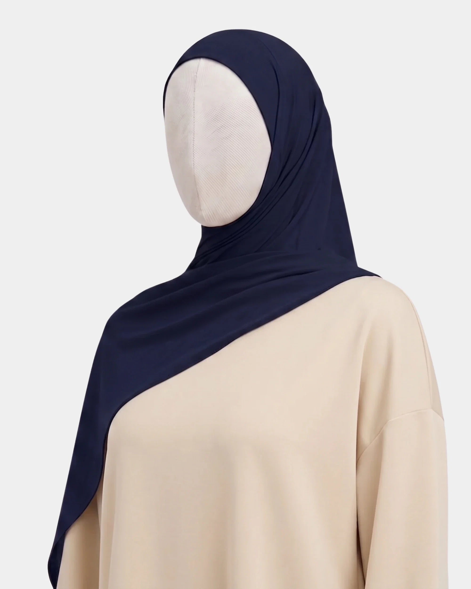 Hijab jersey modal bleu marine porté de profil, drapé fluide sur l'épaule, tissu souple et respirant