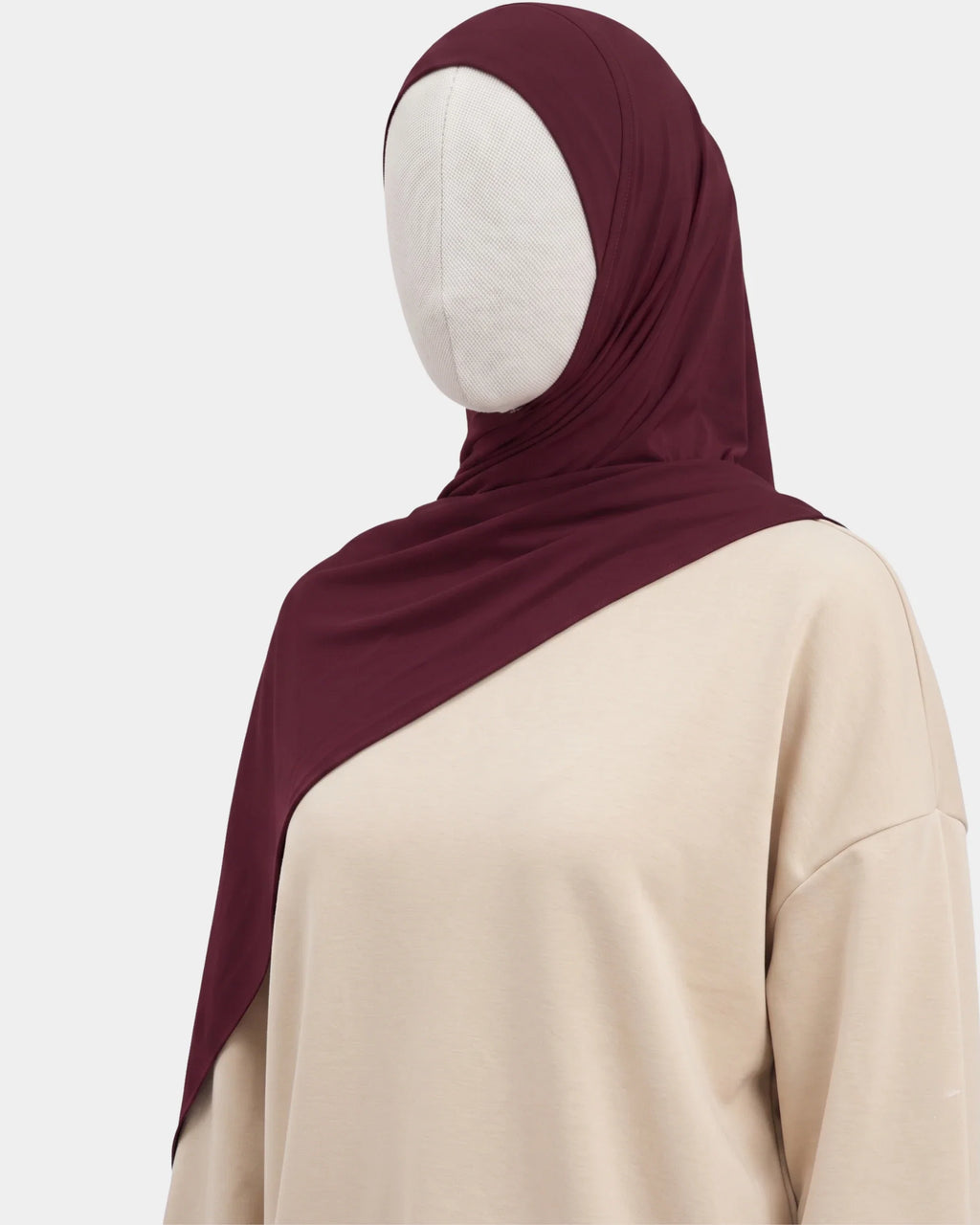 Hijab jersey modal bordeaux porté de profil, drapé fluide sur l'épaule, tissu souple et respirant