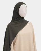 Hijab jersey modal kaki porté de profil, drapé fluide sur l'épaule, tissu souple et respirant