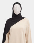 Hijab jersey modal noir porté de face, encadrant le visage, tissu souple et respirant