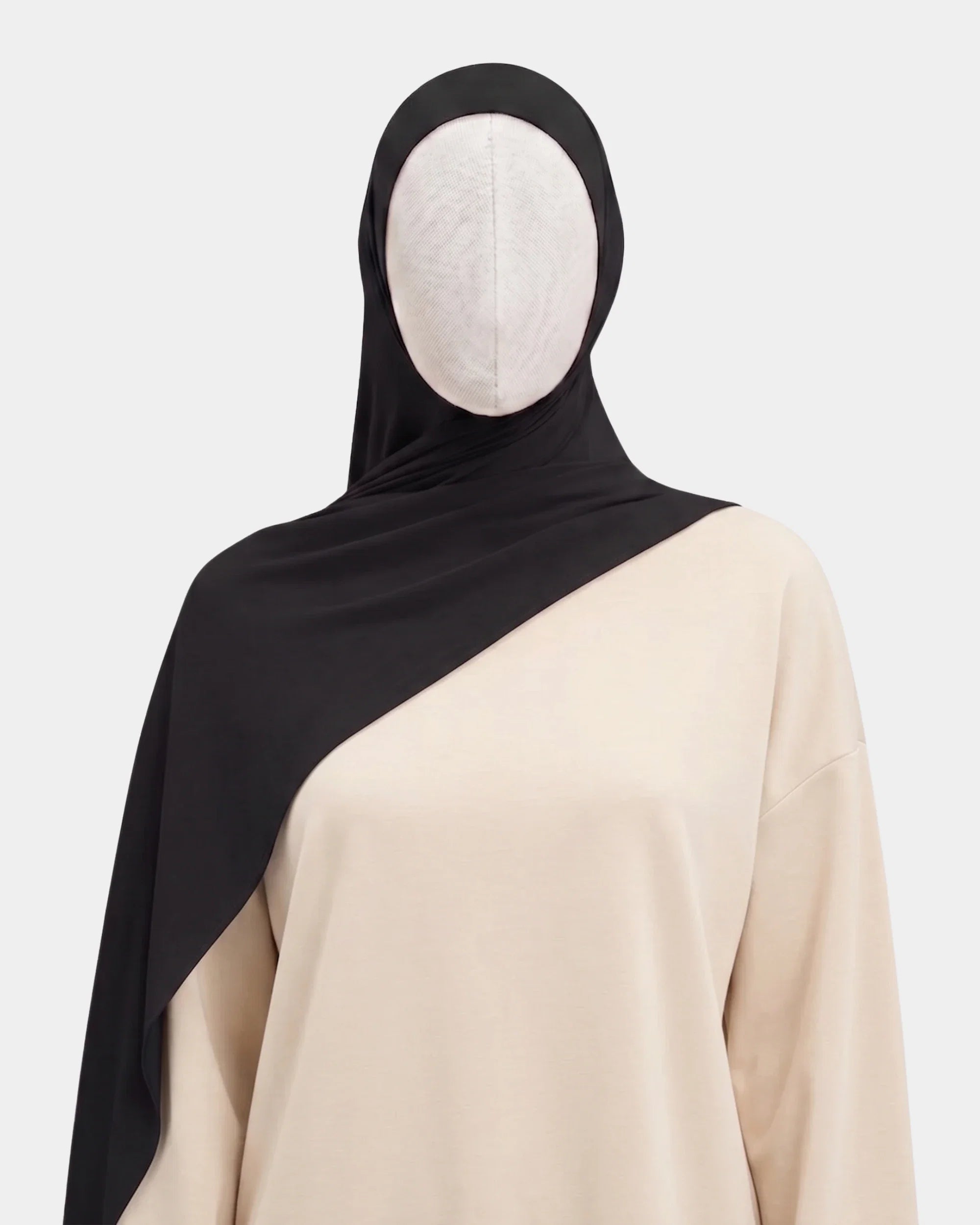 Hijab jersey modal noir porté de face, encadrant le visage, tissu souple et respirant