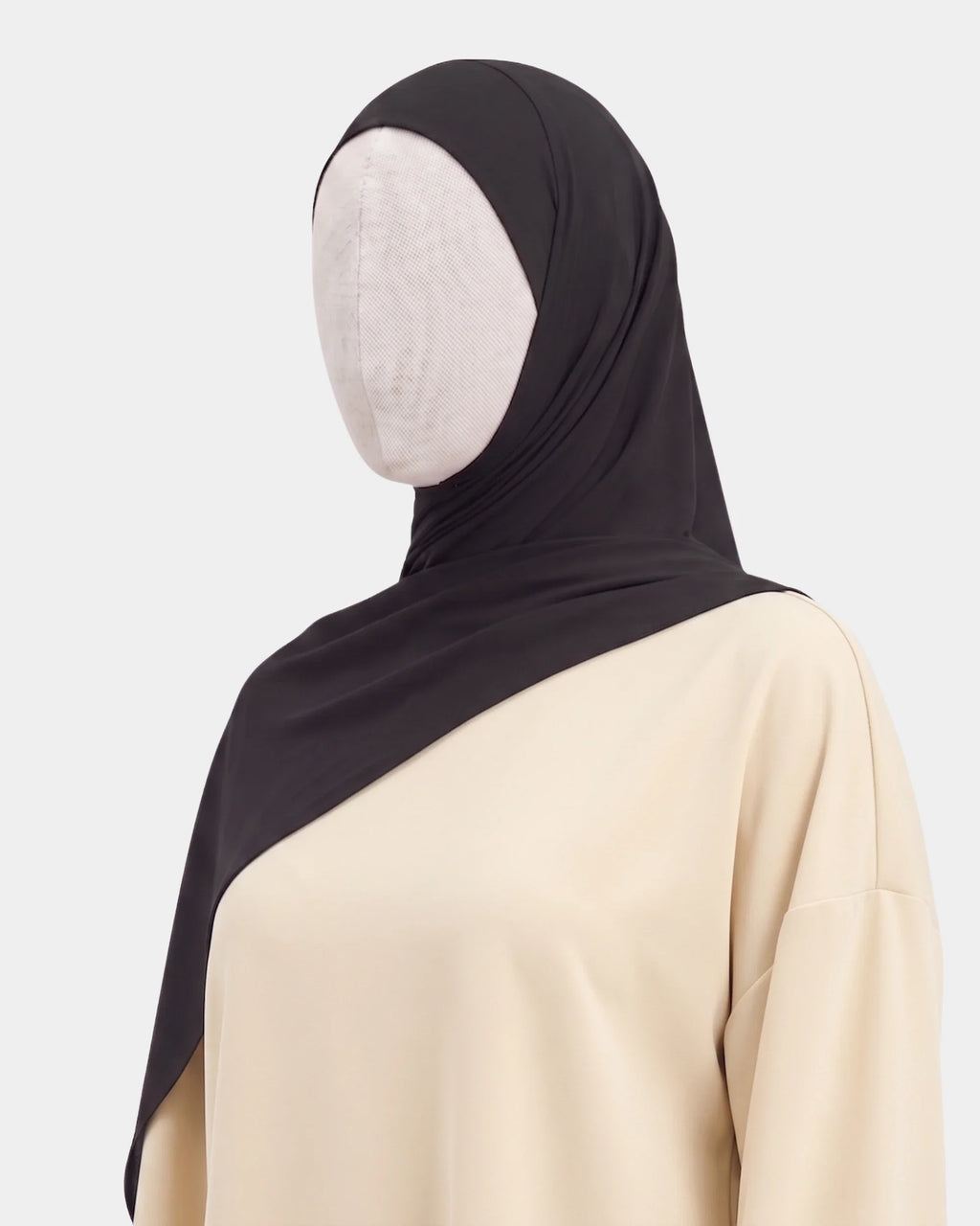 Hijab jersey modal noir porté de profil, drapé fluide sur l'épaule, tissu souple et respirant